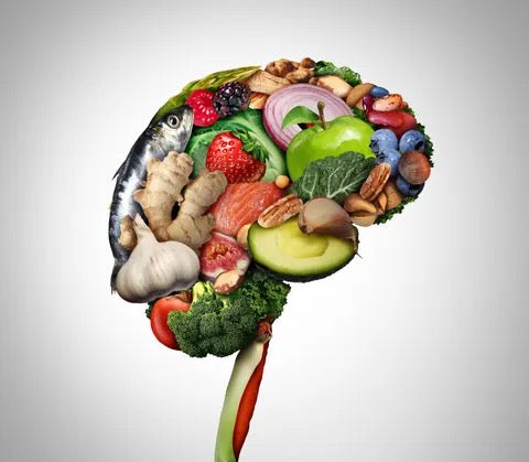 Brain shape made of healthy foods including fish, vegetables, fruits, nuts, and garlic, on white background.