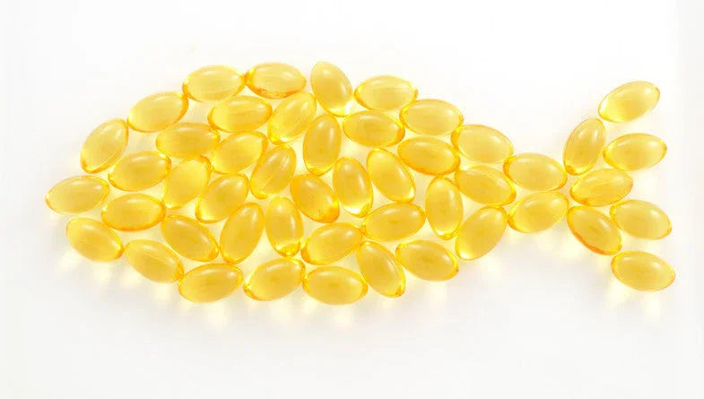 Fish oil softgel capsules arranged in the shape of a fish on a white background